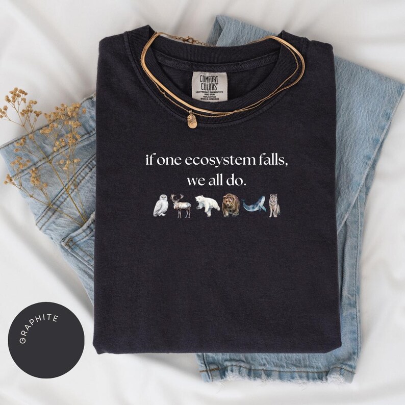 May include: Black t-shirt with the text "if one ecosystem falls, we all do." and a row of animal illustrations below the text.