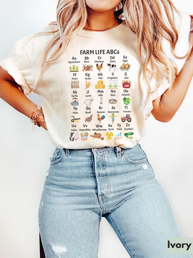 May include: A white t-shirt featuring a graphic of farm-related items and the text "FARM LIFE ABCS". Each item is paired with a letter of the alphabet and a word describing the item. For example, "Aa Agriculture" is paired with a small image of a plant.