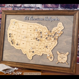 May include: A wooden map of the United States with baseballs marking the location of major league ballparks. The map is framed in dark walnut wood and has the text "All American Ballparks" at the top. The text "Stadium" is at the bottom right corner of the map, with the text "Your Custom Text" below it.