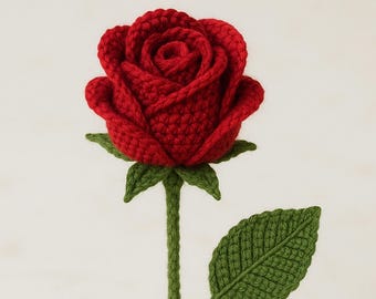 May include: A handmade, red crochet rose with green stem and leaves. The rose has detailed petal work, showing a textured, three-dimensional design. The green stem and leaves provide a natural contrast to the vibrant red flower.