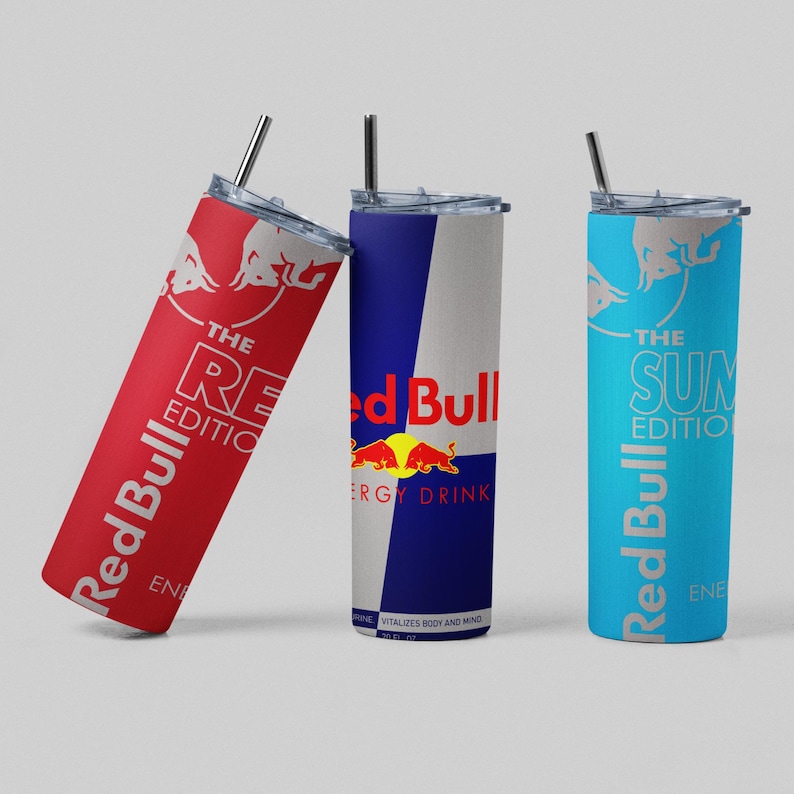 May include: Three Red Bull-branded stainless steel tumblers with straws. One is red with "The RE Edition" text, another is blue and white with the Red Bull logo, and the third is light blue with "The SUN Edition" text.