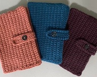 May include: Three crocheted zippered pouches in pink, blue, and purple. Each pouch has a button closure and a strap.