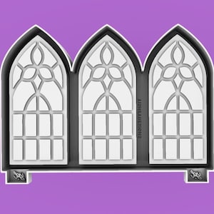 May include: A white silicone mold of three arched windows with stained glass designs. The mold is on a purple background.