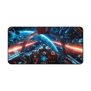 May include: A rectangular mouse mat with a detailed illustration of a spaceship cockpit. The scene shows a space battle with red laser beams, asteroids, and a blue planet in the background. The cockpit is filled with various gauges and controls.