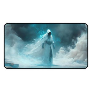 Peut inclure: Tapis de souris avec une illustration numérique d'une figure encapuchonnée vêtue d'une robe blanche, dans un environnement brumeux et éthéré. La figure, au visage sombre, se dresse devant des nuages tourbillonnants bleus et blancs.
