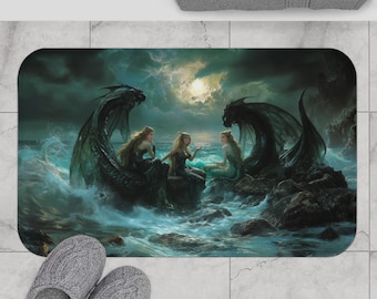 May include: A rectangular bath mat depicting a fantasy scene with three mermaids and two dragons in a stormy ocean setting. The mat has a dark colour palette with shades of blue, green, and black. The mat is placed on a tiled floor with grey slippers.