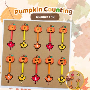 Pode incluir: Um conjunto educativo Pumpkin Counting com os números 1-10. O display inclui dez recortes de abóbora laranja com pontos pretos, fixados em palitos coloridos, emparelhados com dez recortes de folhas de bordo rotulados com os números 1 a 10 em branco.