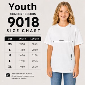 May include: A white t-shirt size chart for Youth Comfort Colors 9018. The chart lists sizes XS through XL with corresponding width and length measurements in inches. A diagram shows a white t-shirt with arrows indicating width and length.