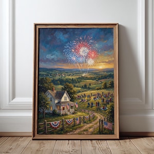 May include: A framed landscape painting depicting a rural scene at dusk with red, white, and blue fireworks in the sky. A house with a porch sits near a dirt path, and a group of people gathers on a grassy hill. A wooden fence features bunting.