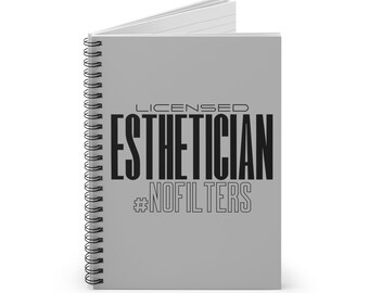 Könnte beinhalten: Ein graues Spiralnotizbuch mit dem Text "LICENSED ESTHETICIAN #NOFILTERS" in Schwarz.