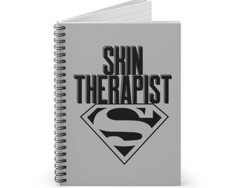 Könnte beinhalten: Graues Spiralnotizbuch mit dem Text "SKIN THERAPIST" in schwarzen Fettdruckbuchstaben und einem schwarzen Superman-Logo.