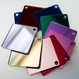 May include: A set of ten square mirror tiles in various colors, including silver, gold, red, pink, purple, green, blue, and red. Each tile has a small hole in the corner.