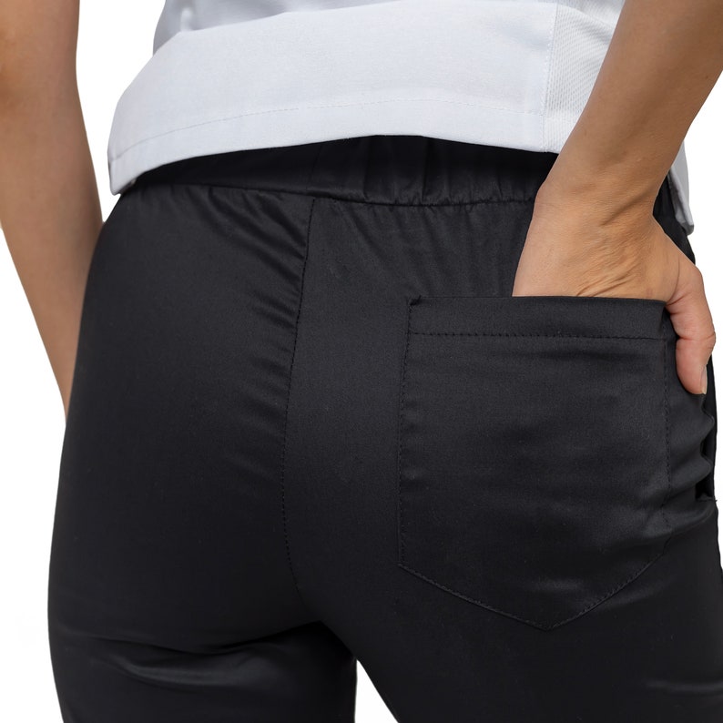 May include: Black pants with a back pocket. The pants have a drawstring waistband.