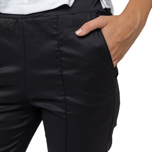 May include: Black satin pants with a front seam detail and a side pocket.