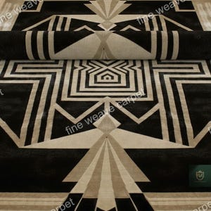Pu&ograve; includere: Un tappeto arrotolato in stile art d&eacute;co nero e beige con motivi geometrici. Il tappeto presenta forme ripetute e il testo "fine weave carpet". La combinazione di colori &egrave; nero, beige e crema.