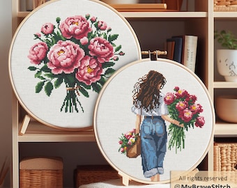 May include: Two cross-stitch hoops. One features a bouquet of pink peonies, the other depicts a person carrying flowers. Both are in wooden hoops, displayed on a shelf. The text "All rights reserved @MyBraveStitch Hanna Levchuk" is visible.