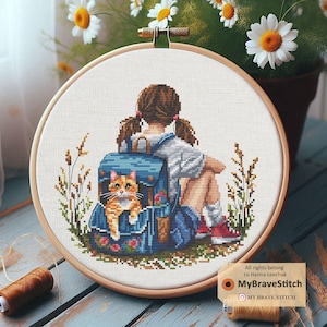 May include: A cross-stitch pattern depicting a girl with a backpack and a cat sitting beside her. The girl is wearing a blue shirt and a red dress. The cat is orange and white. The background is a green field with flowers.