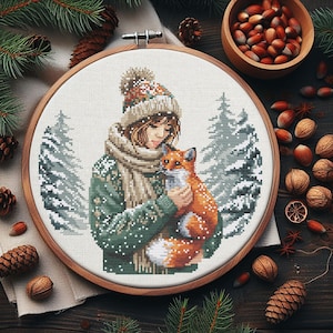 May include: A cross-stitch pattern featuring a girl wearing a green and white sweater, a brown hat, and a white scarf, holding a red fox in her arms. The background is a snowy forest scene.