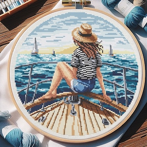 Puede incluir: Una mujer con un sombrero de paja se sienta en un barco, mirando hacia el océano. El agua es azul y el cielo es azul claro. Hay otros barcos en la distancia.