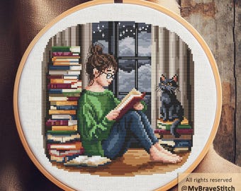 May include: Cross-stitch embroidery in a wooden hoop depicts a person reading by a window, surrounded by stacks of books. A black cat sits on a pile of books. The scene is set against a night sky backdrop. The text "All rights reserved @MyBraveStitch Hanna Levchuk" is visible.