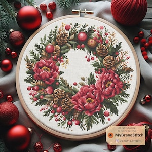 Op de afbeelding: Een kerstkrans met rode pioenen, dennentakken, dennenappels en rode bessen. De krans is in een houten ring en is omringd door rode kerstballen.