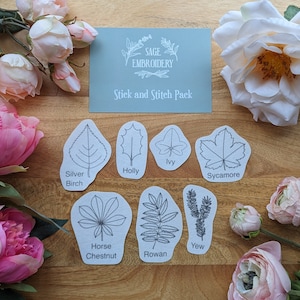 May include: A set of 8 embroidery patterns featuring different types of leaves, including holly, ivy, sycamore, silver birch, horse chestnut, rowan, and yew. The patterns are printed on white paper with black outlines and are labelled with the name of each leaf. The text "Stick and Stitch Pack" is printed on a light blue background.