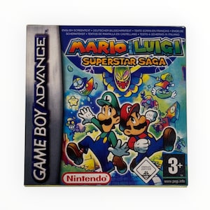 May include: A Game Boy Advance game cartridge case for "Mario & Luigi: Superstar Saga." The case features a colorful illustration of Mario and Luigi, with the game's title in large letters. The Nintendo logo is visible.