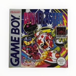 Könnte beinhalten: Game Boy-Spielkassette für Dynablaster, ein Videospiel mit einem Robotercharakter mit einer Bombe. Die Schachtel ist blau, silber und gelb mit dem Spieltitel in fetten, roten Buchstaben. Das Spiel ist kompatibel mit Game Link Game Pak.