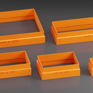 May include: Set of five orange plastic rectangular cookie cutters. The cutters are different sizes and have measurements printed on the bottom. The measurements are 150 x 100, 100 x 60, 70 x 60, 60 x 35, and 50 x 50.