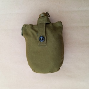 May include: A green canvas canteen with a metal top and a button closure.