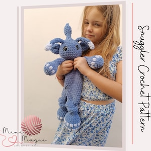 Puede incluir: Una niña pequeña sostiene un juguete de peluche azul tejido a crochet con detalles blancos. El juguete tiene un hocico largo y orejas grandes. La niña lleva un vestido floral. El texto "Smuggler Crochet Pattern" es visible en la imagen.