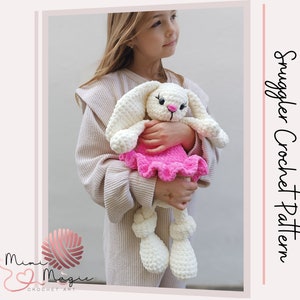 Può includere: Un coniglietto bianco all'uncinetto con un vestito rosa a balze. Il coniglietto è tenuto da una bambina. L'immagine include il testo "Smuggler Crochet Pattern".