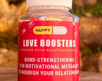 May include: A red and white bottle with a white lid filled with colorful capsules. The label reads "HAPPY JOTS LOVE BOOSTERS EMPOWER YOUR RELATIONSHIP DAILY BOND-STRENGTHENING FUN MOTIVATIONAL MESSAGES TO NOURISH YOUR RELATIONSHIP ESSENTIAL SOUL VITAMINS 60 capsules".