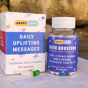 Pode incluir: Dois frascos de pílulas azuis e brancas com tampas brancas. O frasco à esquerda diz "Happy Jots Mensagens diárias inspiradoras Vitaminas essenciais para a alma 60 cápsulas". O frasco à direita diz "Happy Jots Impulsionadores de fé Fortaleça seu espírito diariamente Versículos bíblicos que fortalecem a alma Para nutrir sua fé Vitaminas essenciais para a alma 60 cápsulas".