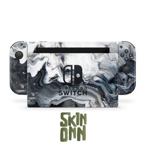 May include: A Nintendo Switch console with a marble-like design in shades of gray and white. The console and controllers feature a swirling pattern. The text "NINTENDO SWITCH" is visible on the console. The brand name "SKIN ONN" is also displayed.