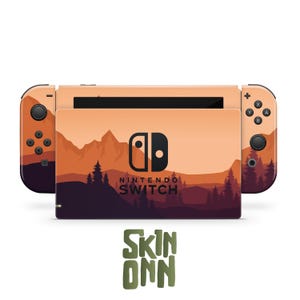 Könnte beinhalten: Eine Nintendo Switch-Konsole mit einem individuellen Skin mit einem Berglandschaftsdesign in Orange-, Braun- und Lilatönen. Der Skin enthält das Nintendo Switch-Logo und das Skin Onn-Logo.