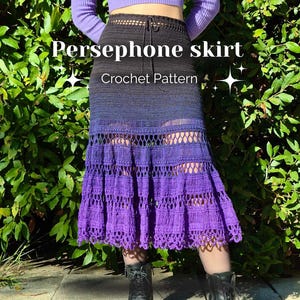 Puede incluir: Falda de ganchillo hecha a mano en tonos negro, azul y morado. La falda presenta una cintura alta y un diseño escalonado con detalles calados. El texto "Persephone skirt Crochet Pattern" se muestra en la falda.