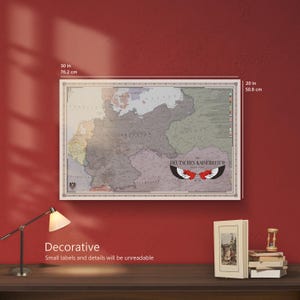 May include: A rectangular wall map titled Deutsches Kaiserreich featuring a muted colour palette of grey, beige, and light blue. The map measures 76.2 cm by 50.8 cm and displays historical borders with a central eagle emblem and text labels.