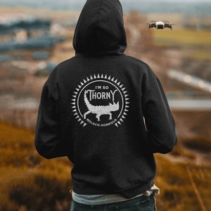 May include: Black hooded sweatshirt with a white graphic of a lizard with the text "I'm so Thorny" and "Moloch Horridus" underneath.