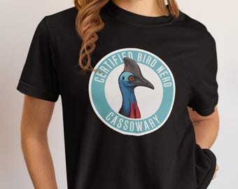 Op de afbeelding: Zwart T-shirt met een cirkelvormige afbeelding van een kasuarisvogel. De afbeelding staat in een lichtblauwe cirkel met de woorden "CERTIFIED BIRD NERD CASSOWARY" in het wit.