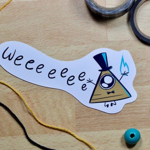 May include: A white sticker with the text "weeeeeee" in black script. The sticker features a cartoon triangle character with a top hat, bow tie, and a blue flame. Yellow and black string, teal beads, and tape are also visible.