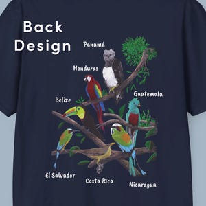 May include: A navy blue t-shirt with a colorful design of birds and trees. The birds are labeled with the names of Central American countries: Panama, Honduras, Belize, Guatemala, El Salvador, Costa Rica, and Nicaragua.