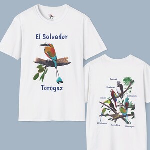 May include: White t-shirt with a blue and green bird illustration and the text "El Salvador Torogoz" printed on the front. The back of the shirt features a colorful illustration of birds with the names of Central American countries.