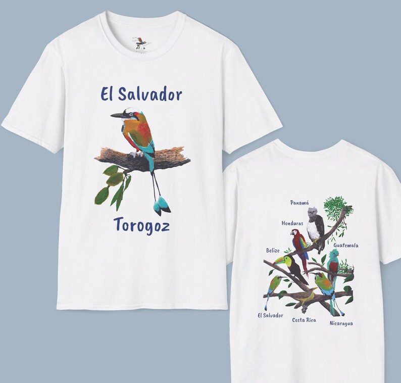 May include: White t-shirt with a blue and green bird illustration and the text "El Salvador Torogoz" printed on the front. The back of the shirt features a colorful illustration of birds with the names of Central American countries.