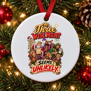 Könnte beinhalten: Ein runder, weißer Keramik-Weihnachtsanhänger mit rotem Band, verziert mit einer bunten Illustration von drei Weisen mit Kamelen, einem Wegweiser, einer Karte und einem Smartphone sowie dem Text Three Wise Men? Seems Unlikely.