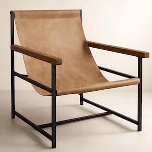 May include: An armchair featuring a black metal frame and a tan leather sling seat. The chair has a high backrest and matching tan leather armrest covers. The design consists of a rectangular frame structure with a suspended seat and back panel.