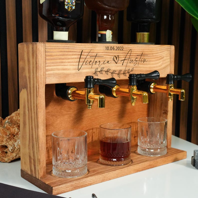 A wooden dispenser with three glass taps, each containing a different colored liquid, likely for serving cocktails or other mixed drinks.