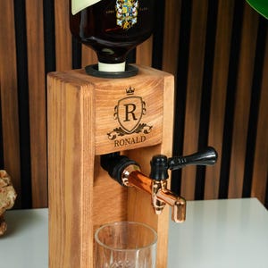 A wooden beer tap dispenser with a copper tap and a glass on a wooden stand.