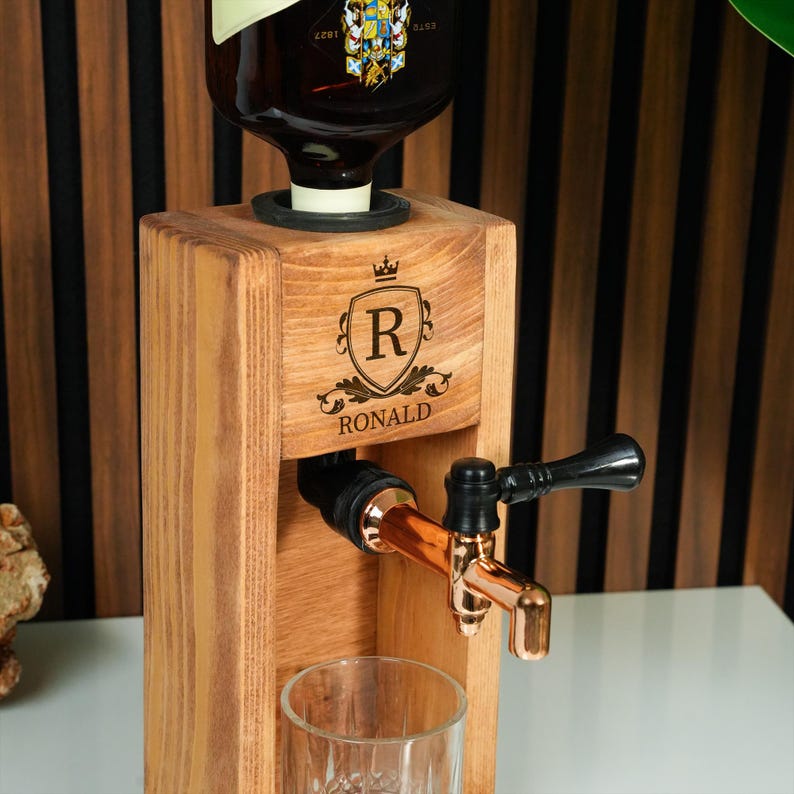 A wooden beer tap dispenser with a copper tap and a glass on a wooden stand.