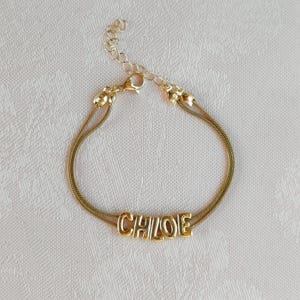 Minimalistische armband met bubbelletters en naam: aanpasbare armband in goud- of zilverkleurige uitvoering.